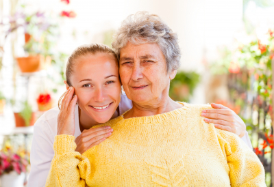 female caregiver hugs senior woman